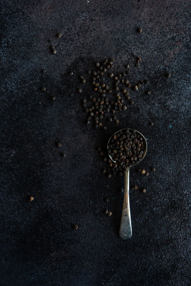 Measurement spoon filled with peppercorns