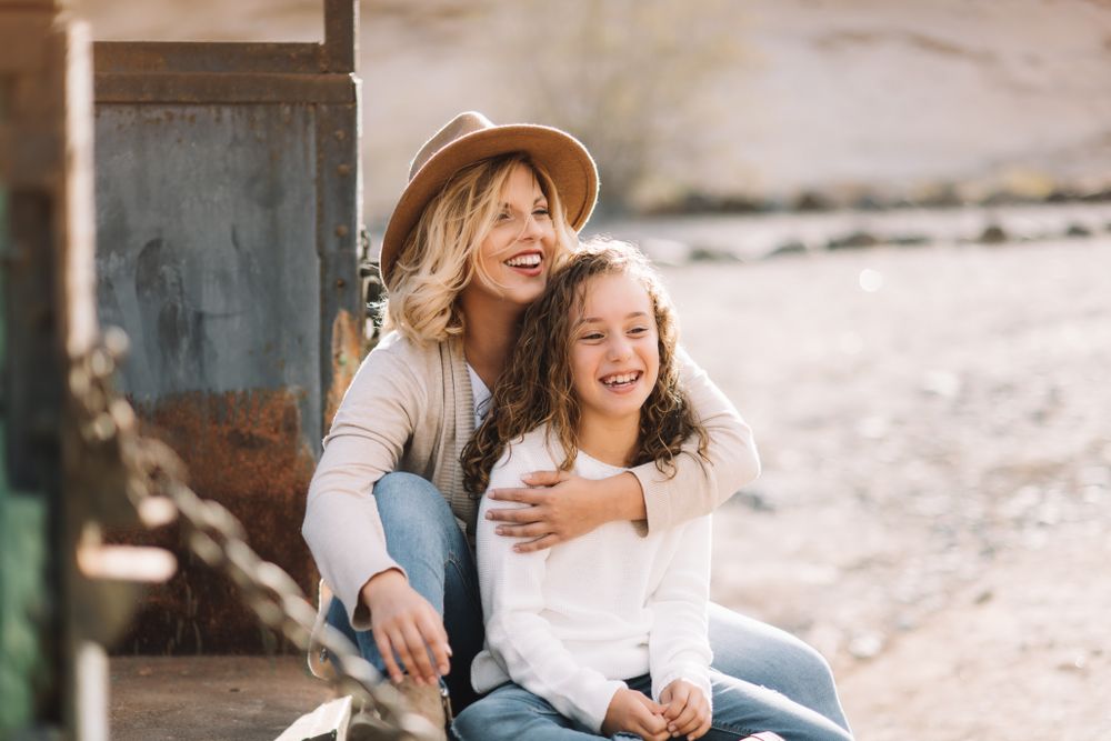 Mother hugging girl in truck body