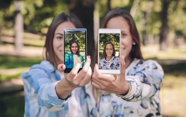 Women showing smartphones with their selfie photos