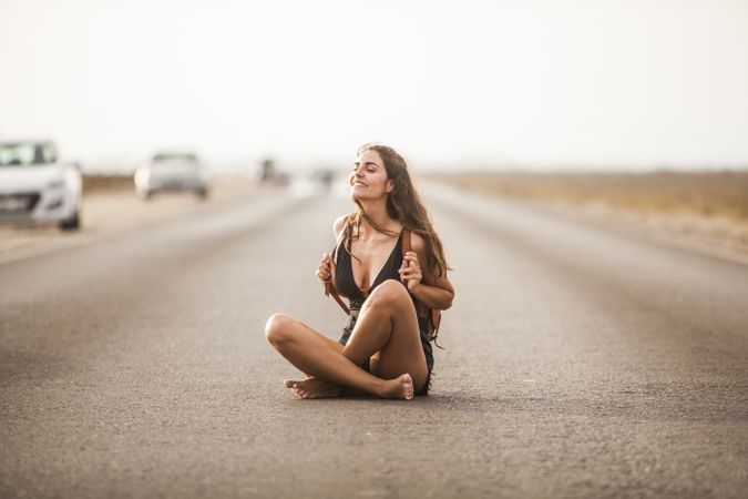 Smiling woman sitting on road