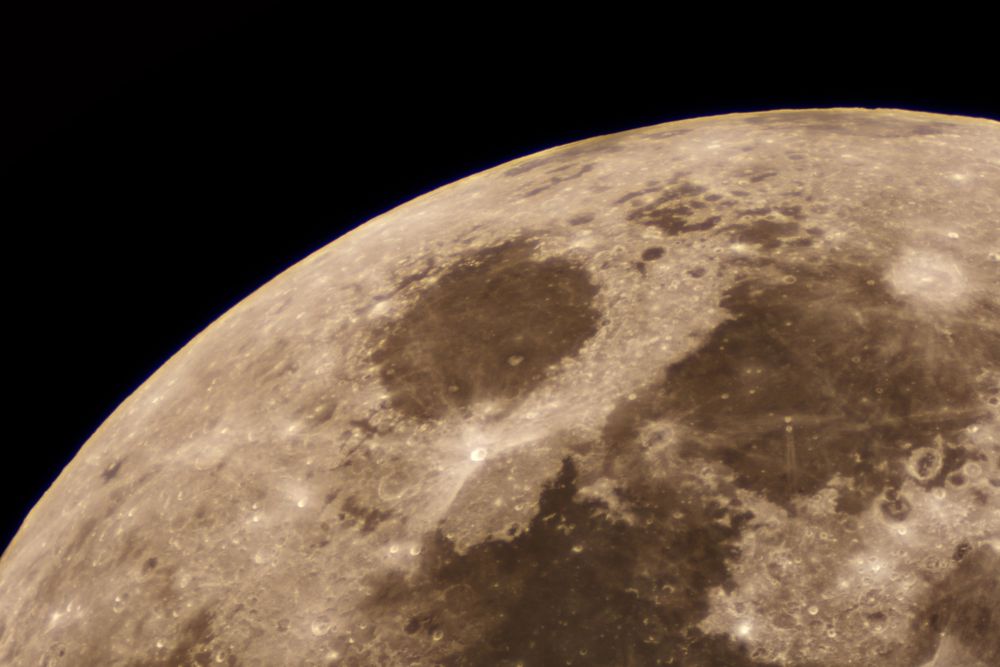 Telescopic view of the moon revealing craters and lunar seas