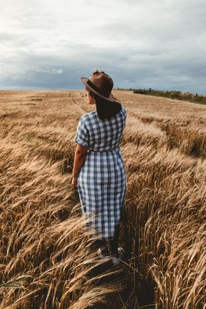 Anonymous woman standing dry field