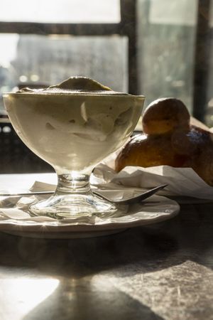 Layered Sicilian granita with pistachio and almond flavors served with brioche in morning sunlight