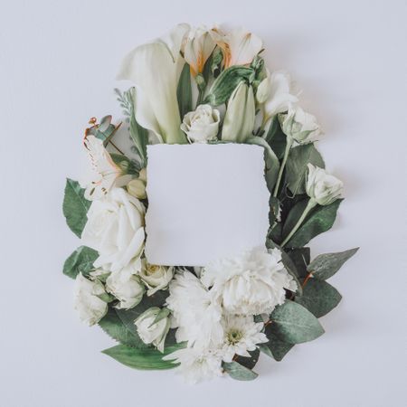 Easter layout with flowers and leaves in cross shape with paper card on light  background