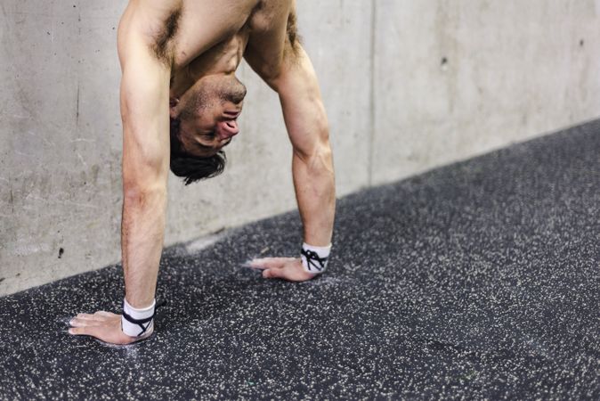 Man doing handstand in gym