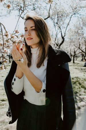 Young happy woman between trees in garden