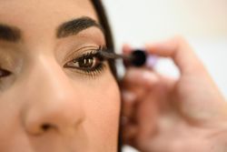 Woman applying product to client’s face