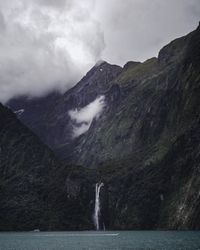 Boat cruising on lake near waterfall