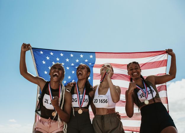 Group of four US athletes with national flag