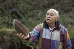 Older man exploring rocks on seashore