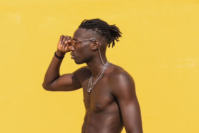 Serious Black man in trendy sunglasses near wall