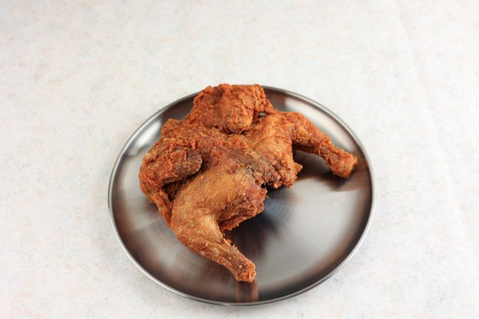 Whole Chicken Fried and Crispy on Silver Korean Plate.