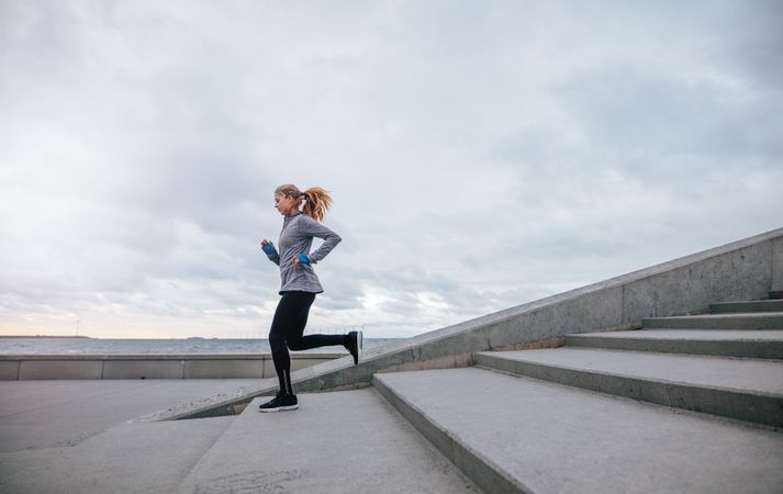 Healthy young woman running down the steps