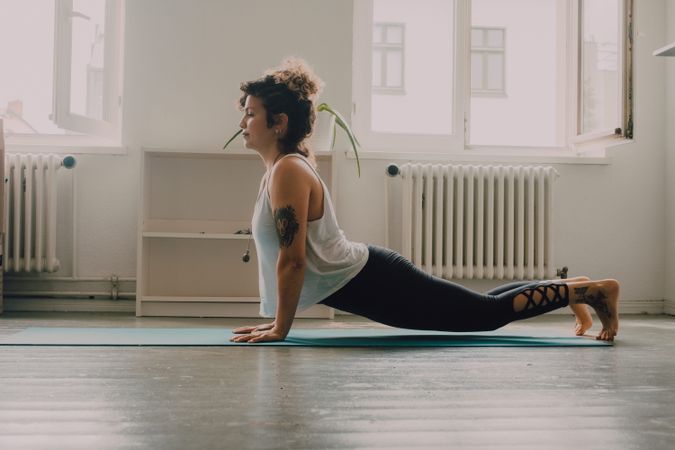 Calm woman practicing yoga pose and balancing on hands at home