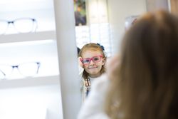 Young girl trying on glasses