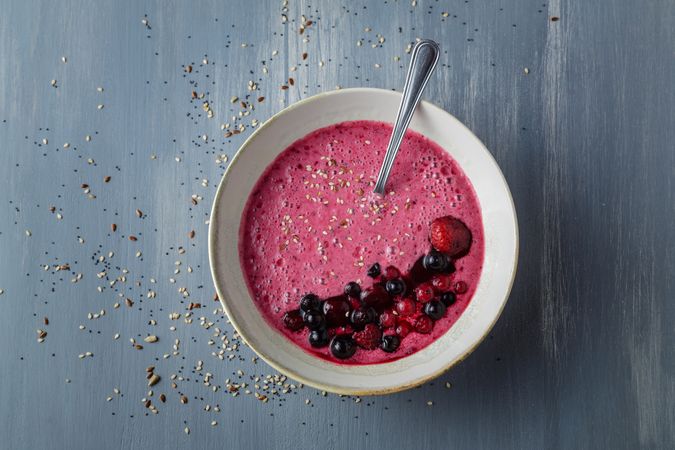 Smoothie bowl with fresh berries and sesame served on table
