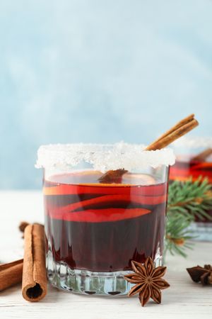Glasses of tasty mulled wine on blue wooden background, space for text
