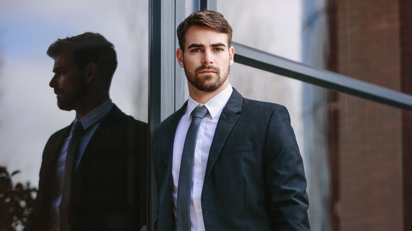 Businessman standing by office building outdoors
