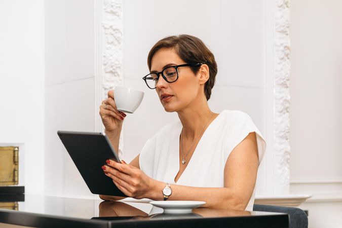 Woman concentrating on her tablet with a coffee