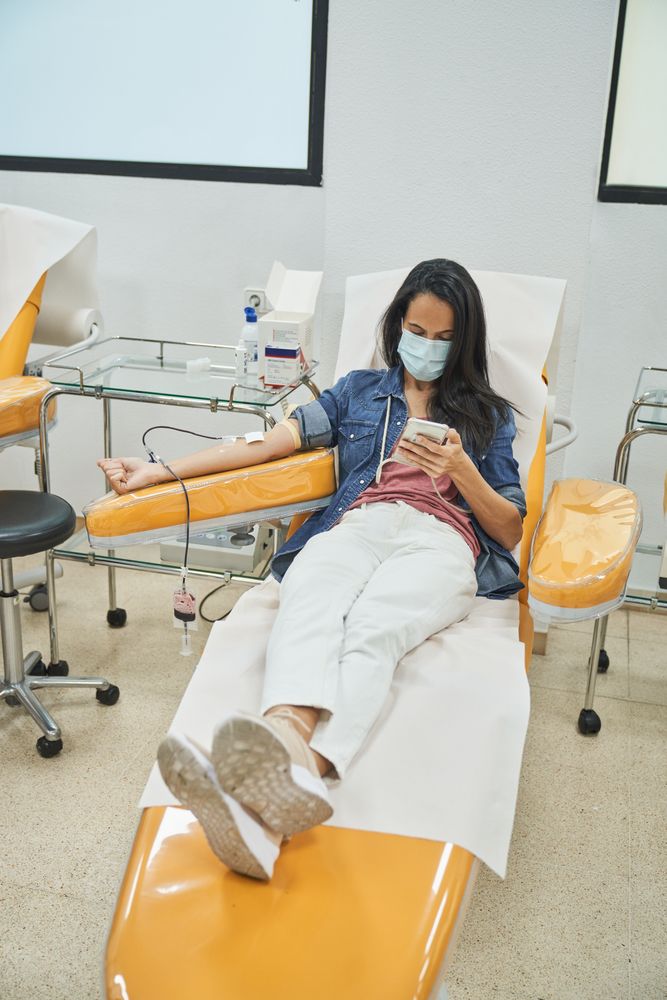 Female patient giving blood in clinic