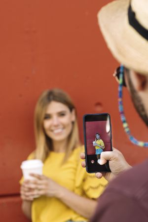 Young woman posing with coffee for man