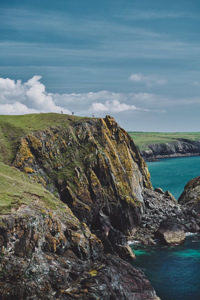 People walking on the cliffs in the distance