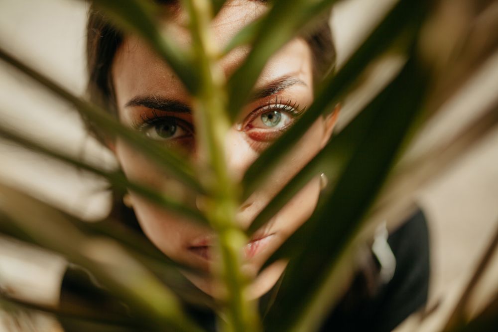 woman behind palm leaf