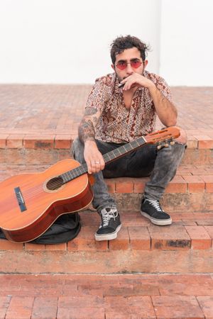 Portrait of street musician sitting on stairs