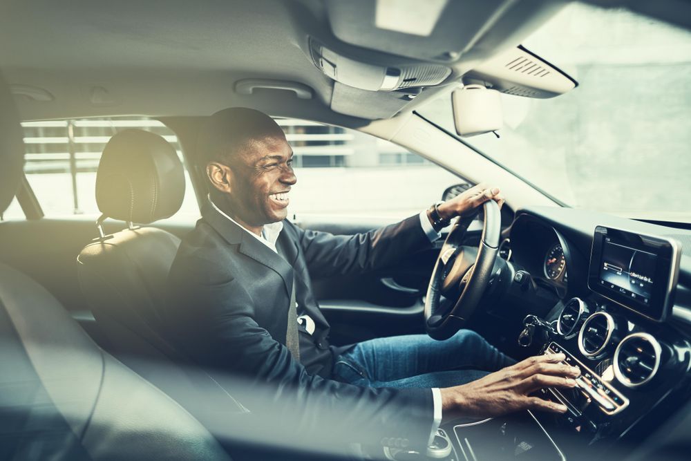 Man laughing while changing radio stations in a vehicle