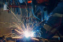 Side view of person welding iron