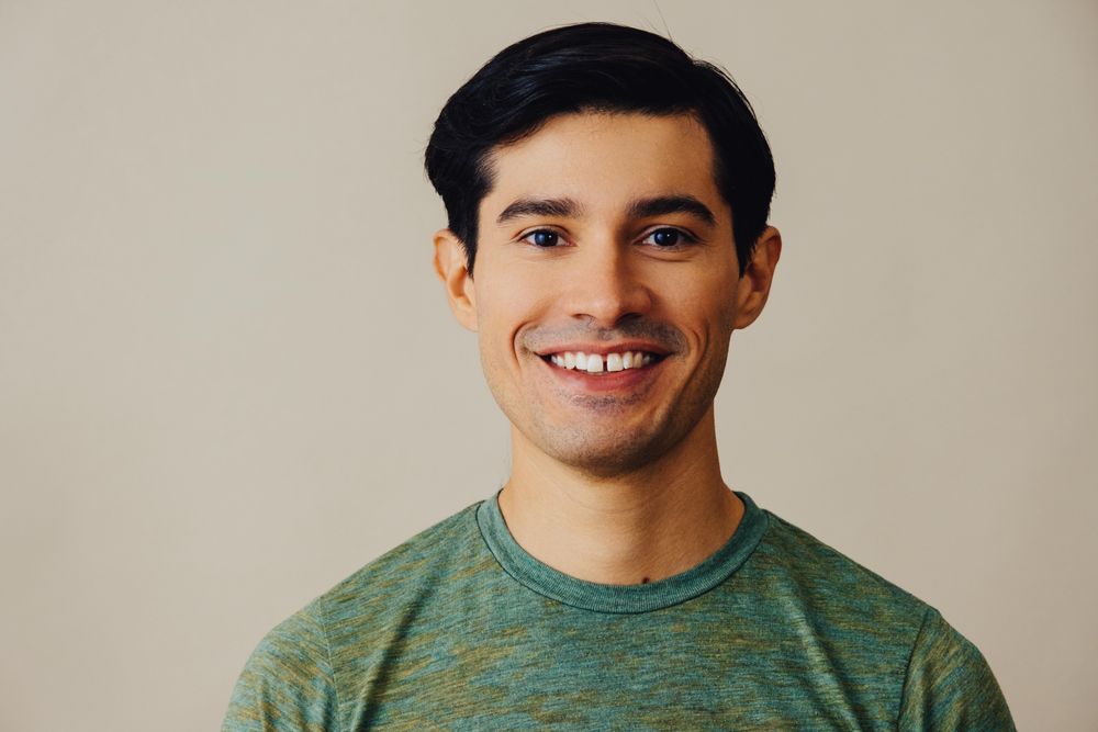 Portrait of happy Hispanic male in neutral room