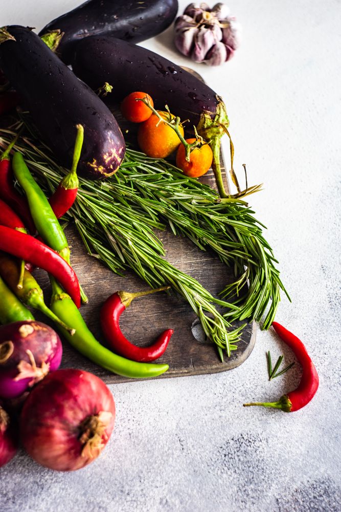 Fresh colorful vegetables and herbs on wooden board with copy space