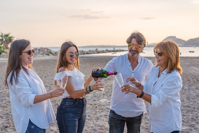 Happy family drinking wine on beach