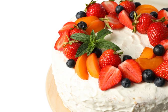 Wooden plate with berry cream cake isolated on plain background