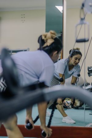 a woman in sportswear at a gym using a cable machine