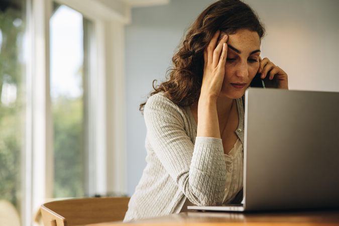 Woman looking stressed out while talking on cell phone