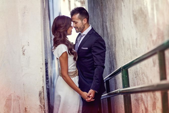 Newlyweds about to kiss on outdoor passageway