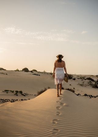 Active woman walking in dry desert barefoot