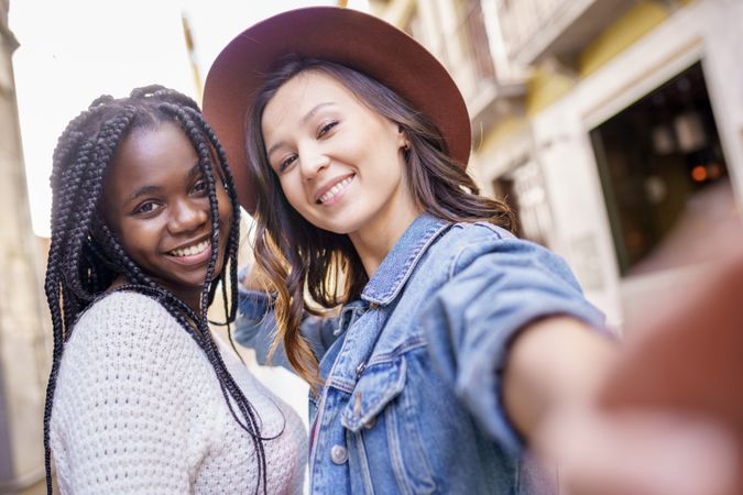 Female friends with extended arm to the camera for a selfie