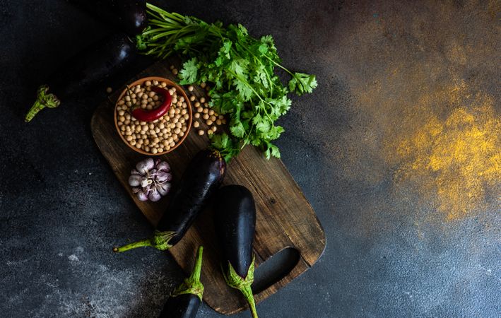 Eggplants and legumes on cutting board with copy space