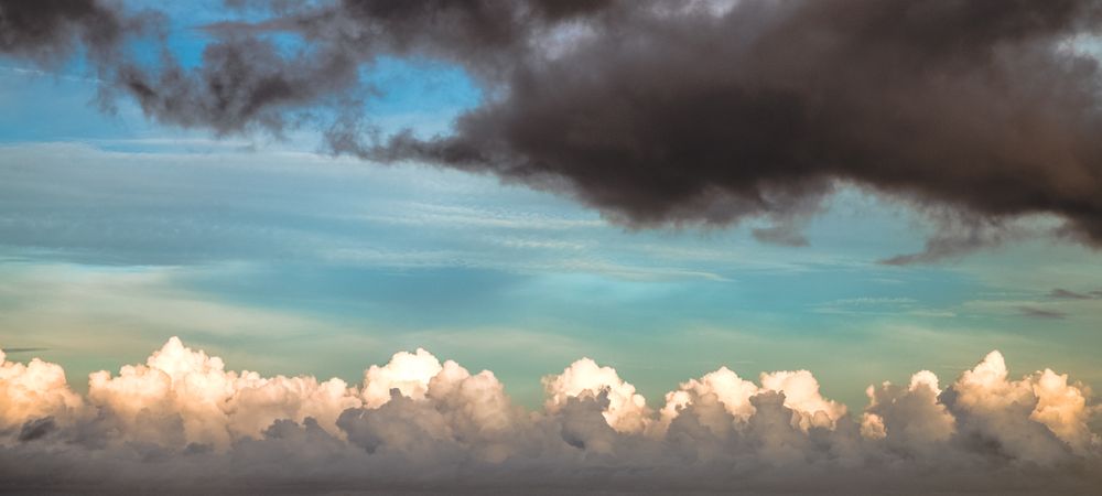 Banner of fluffy clouds in smokey blue sky