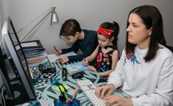 Woman teleworking with her children doing homework