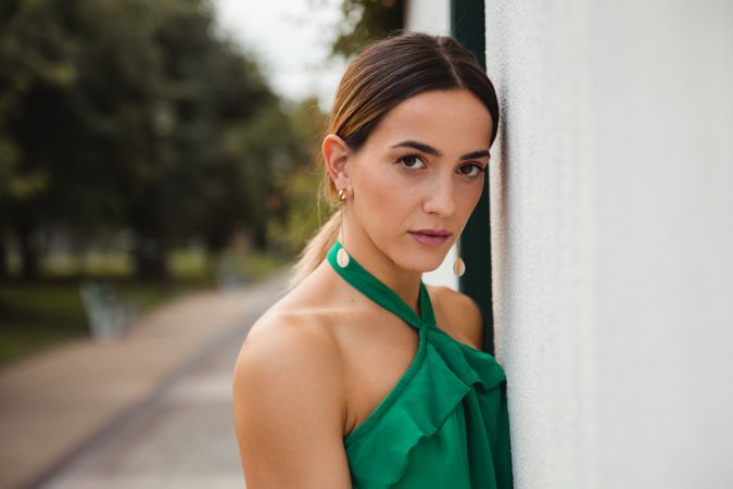 Barefoot woman leaning on house wall
