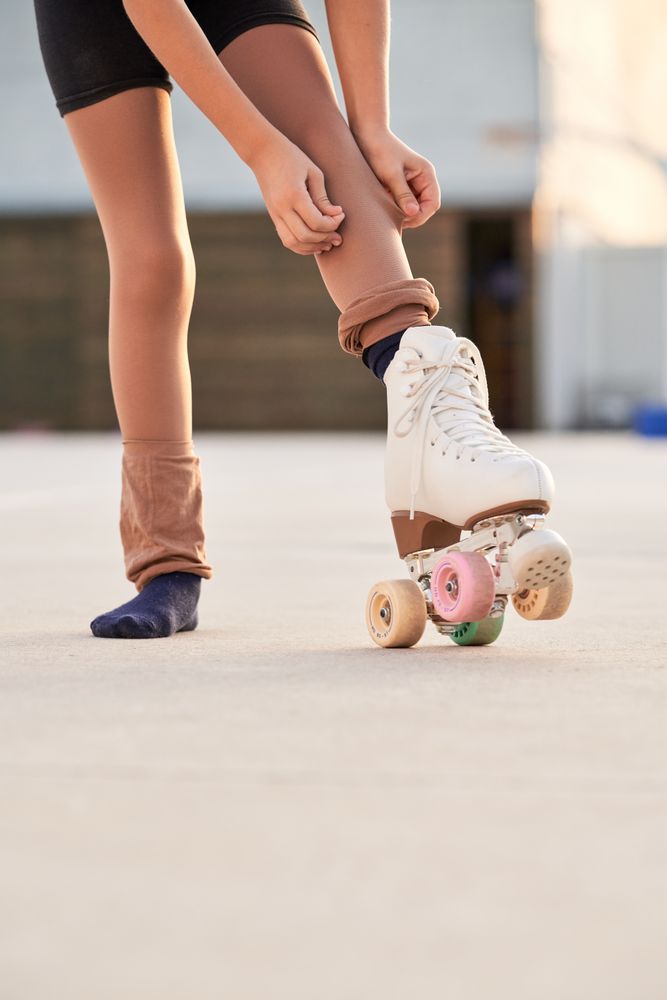 Unrecognizable girl in roller skate preparing for training