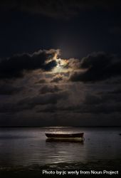 Full moon behind clouds above an ocean with a boat 41OgZ0