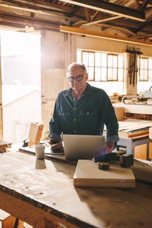 Mature man standing in his carpentry workshop