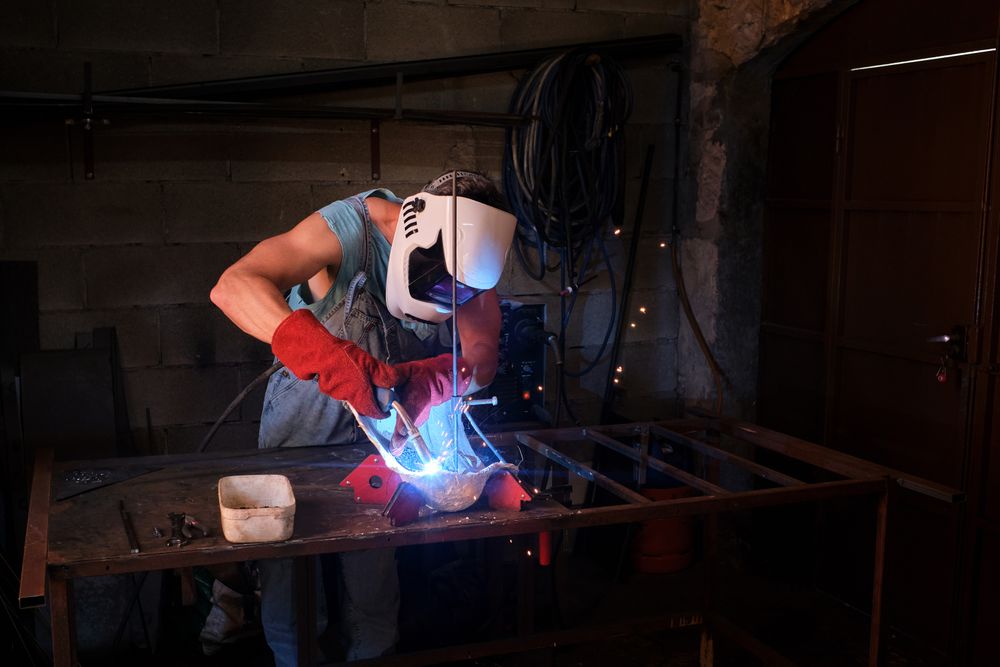 Craftsman in process of welding in garage