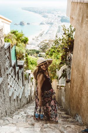Stylish woman picturing coast from stairway
