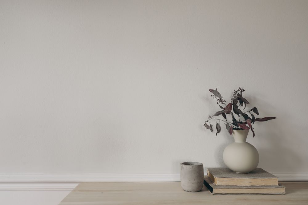 Modern vase with dry eucalyptus tree branches on wooden table