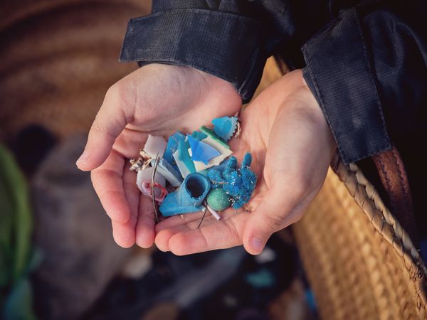 Crop preteen boy with plastic rubbish in palms